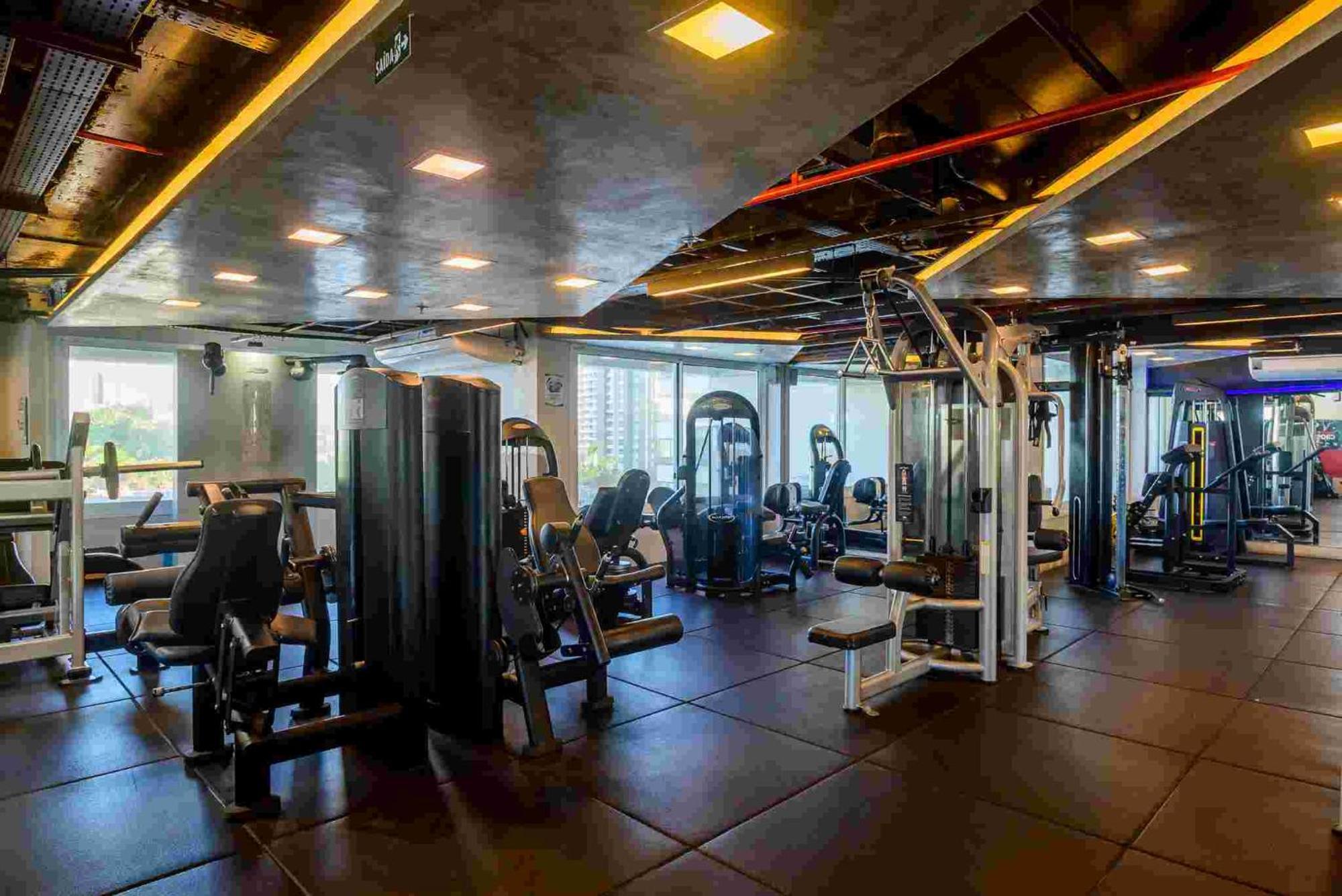 Hotel Luzeiros Sao Luis Extérieur photo The photo shows a modern gym interior featuring various workout equipment. There are several exercise machines arranged throughout the space, including strength training equipment. The room is well-lit with overhead lights and has large windows that 