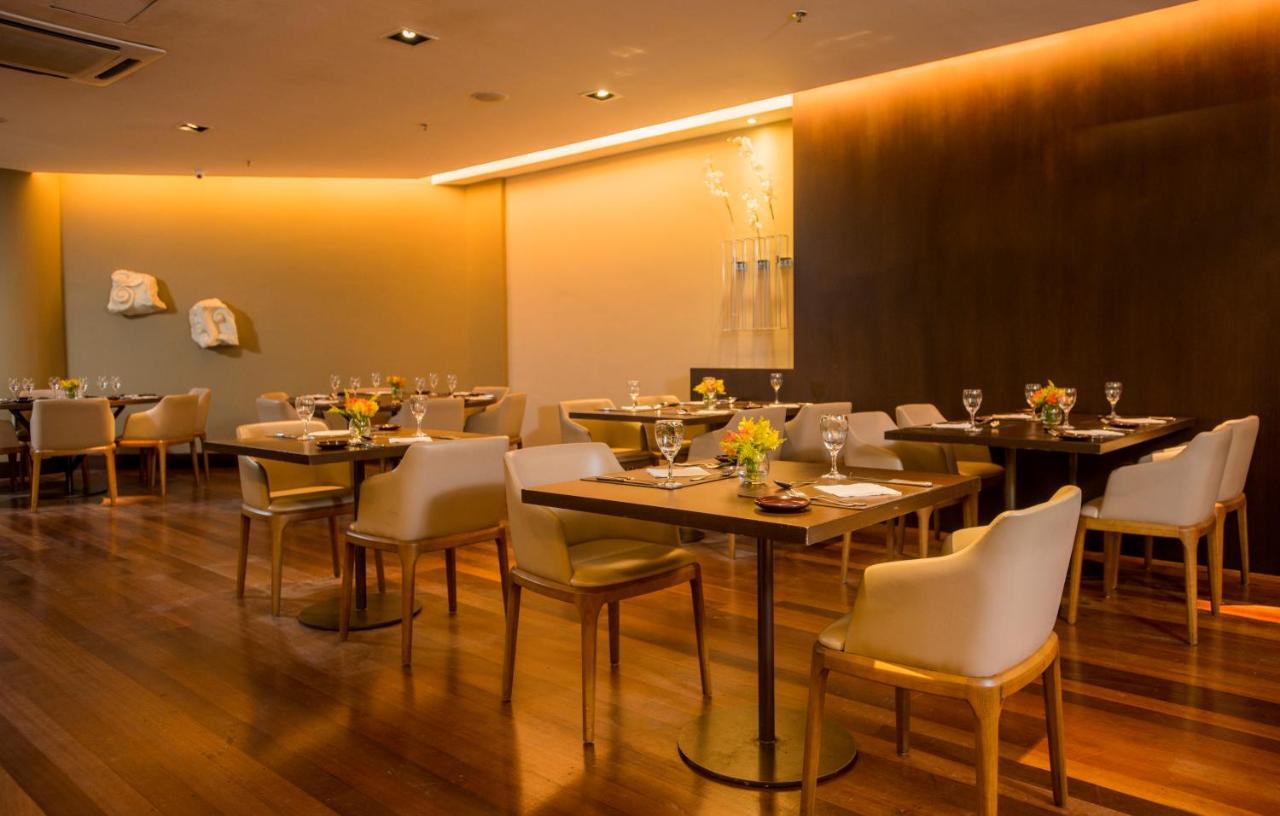 Hotel Luzeiros Sao Luis Extérieur photo The photo depicts a modern restaurant interior. It features wooden flooring and tables set with elegant tableware, including glasses and flowers. The seating consists of upholstered chairs, adding a touch of comfort. The lighting is soft and ambient,