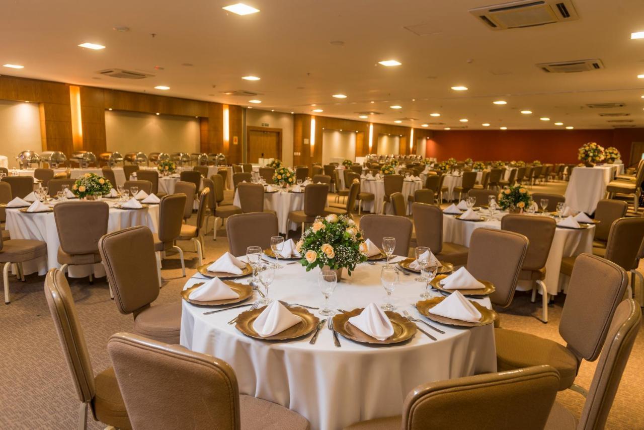 Hotel Luzeiros Sao Luis Extérieur photo The photo depicts a spacious banquet hall set up for an event. Numerous round tables are elegantly arranged with white tablecloths and neatly folded napkins. Each table features a small floral centerpiece. The room is well-lit, with warm lighting hig
