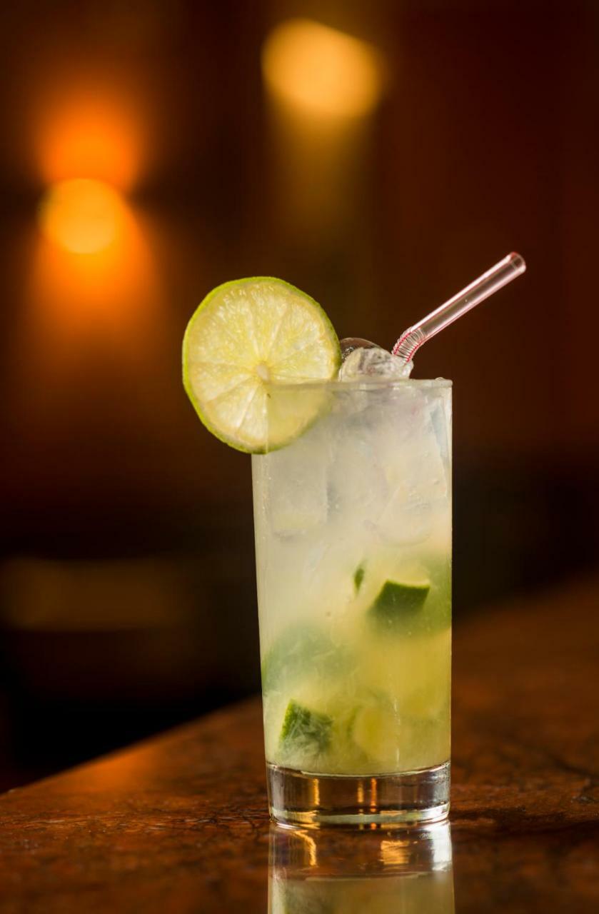 Hotel Luzeiros Sao Luis Extérieur photo The photo shows a refreshing cocktail in a tall glass. It is filled with ice cubes and garnished with a slice of lime on the rim. A straw is placed in the drink, and the liquid appears to be clear with hints of green, likely from lime or mint. The ba
